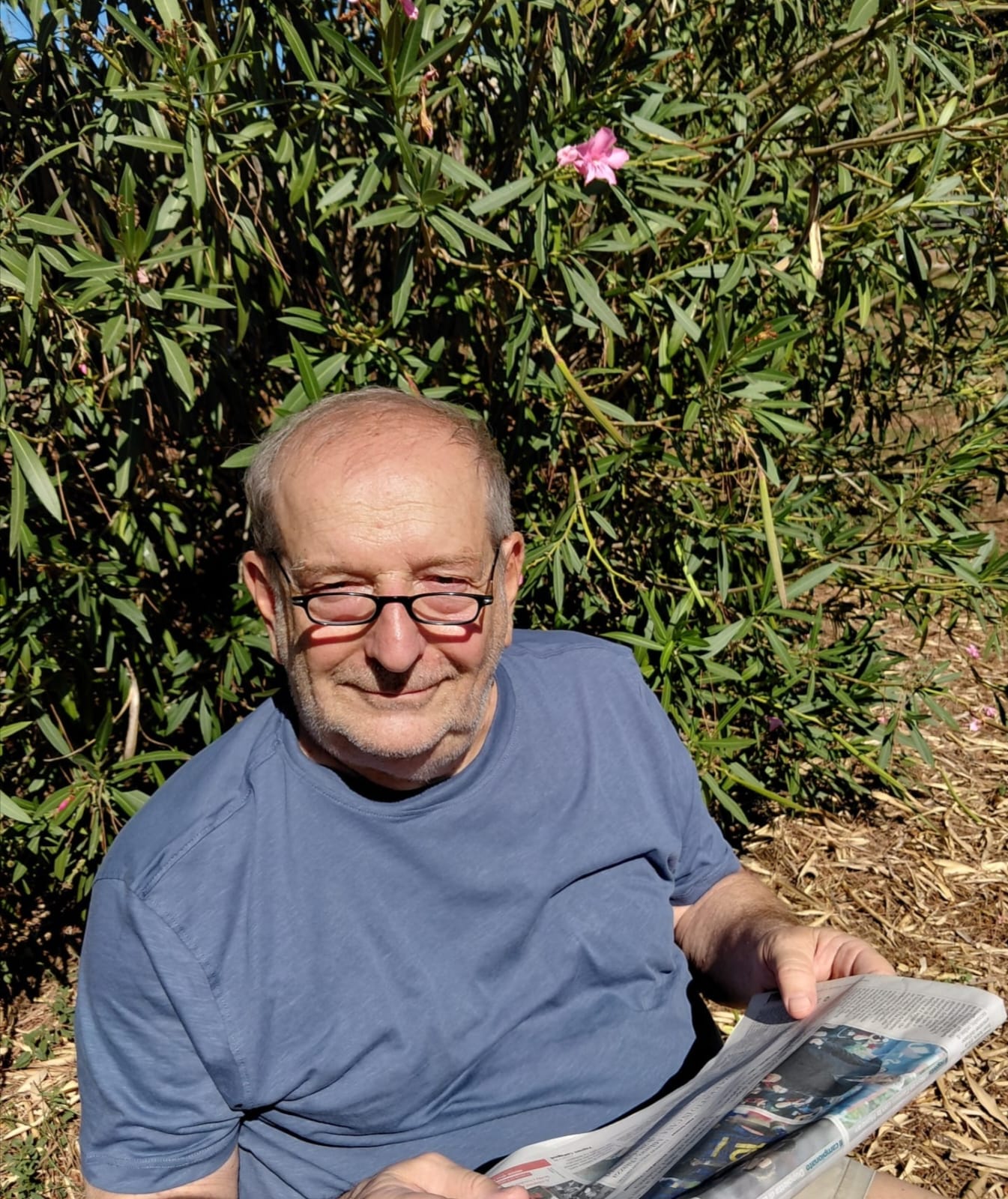 Roberto Grazioli seduto all'aperto con un giornale in mano